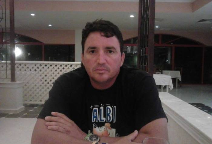 Ernesto Concepción posa con pulóver negro para la cámara sentado en un restaurant.