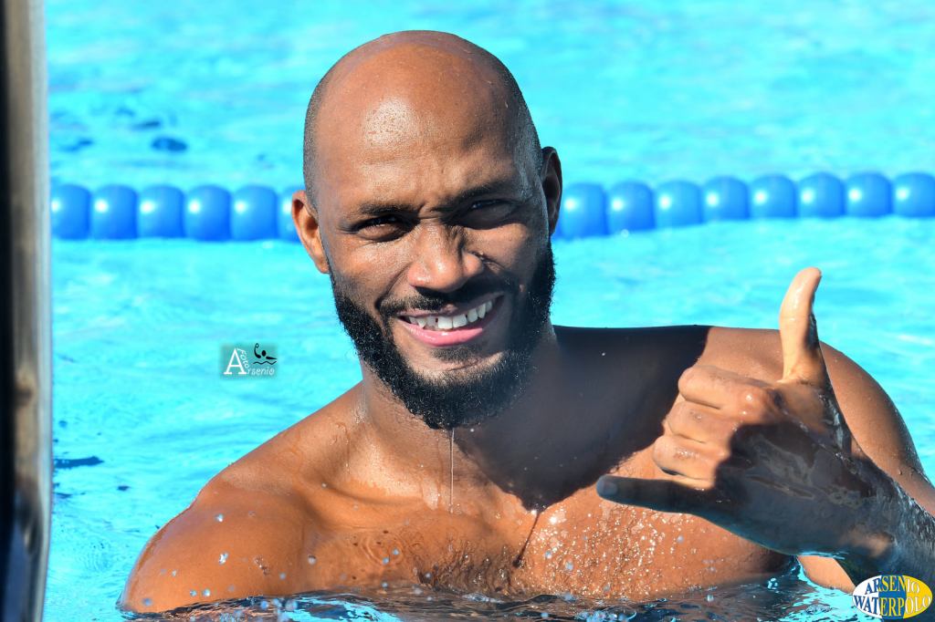 El polista cubano Giraldo Carales hace gesto de llamada al fotografo Arsenio López desde la piscina.